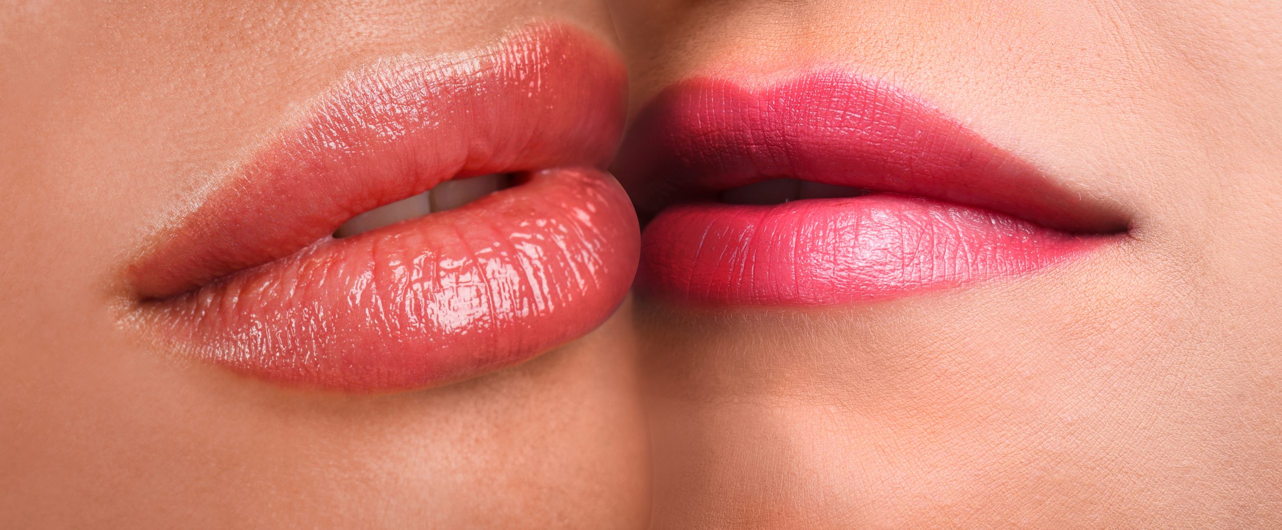 Zwei Frauenmünder mit dezentem Lippenstift, in Großaufnahme, die sich küssen